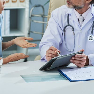 Cropped image of doctor and patient discussing results of tests